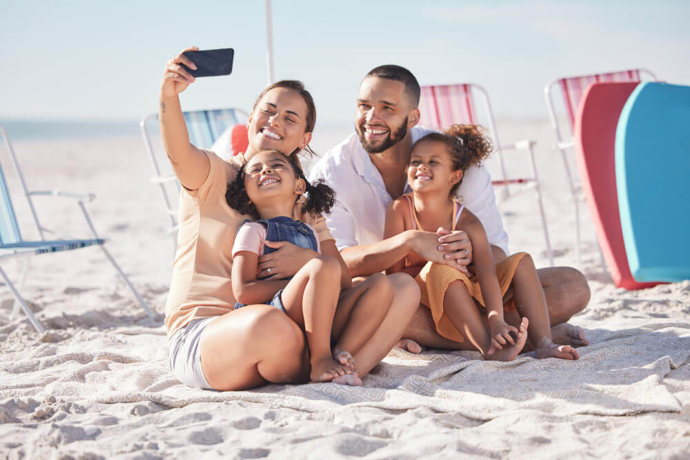 happy family beach selfie with smile together summer vacation bonding relaxing sand mother father children relax sandy shore holiday break weekend smiling happiness