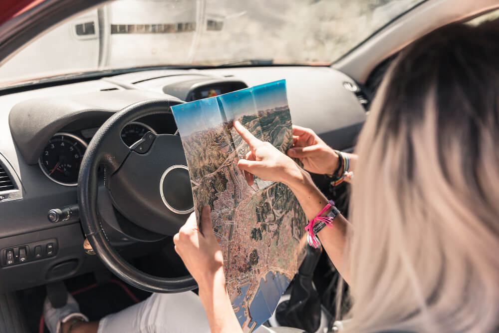 woman sitting car showing map her friend