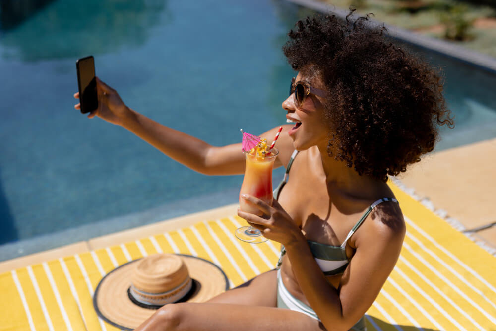 young woman taking selfie near swimming pool